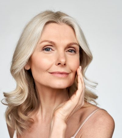 Beautiful gorgeous mid aged mature woman looking at camera isolated on white. Hautverjüngung